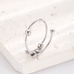 Macro shot of spinning metal beads on the minimalist anti-anxiety ring on stone stand