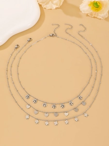 Detail of silver triple necklace set featuring tree of life, heart and clover charms