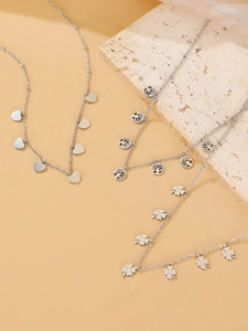 Detailed view of silver stainless steel necklaces with heart, tree of life, and clover pendants