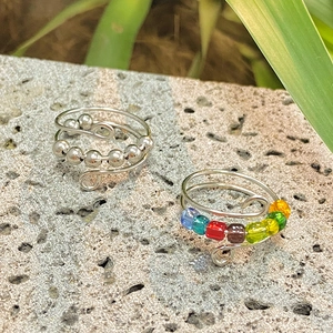 Macro view of spiral anti-stress rings with colorful beads on natural stone surface