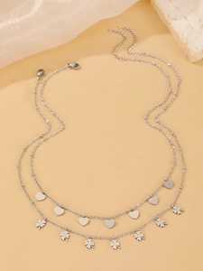 Close-up of double-layer stainless steel necklace with heart and clover charms