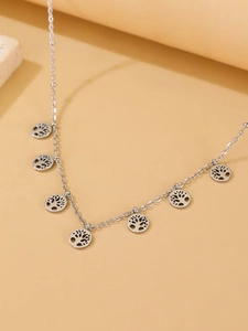 Macro shot of silver stainless steel necklace with hollow Tree of Life circular pendants