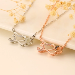 Macro shot of silver and rose gold cat pendants with zircon stones and projection beads
