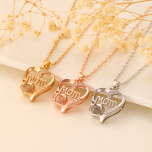 Detailed view of heart pendants with MOM engraving and crystals in three metallic colors