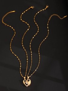 Detail of interlocking heart necklaces with black projection stones and gold sequin chain