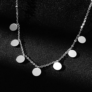 Macro shot of silver titanium steel Y-necklace with seven round metal pendants on silk
