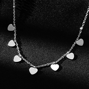 Macro shot of titanium steel necklace featuring seven smooth silver heart-shaped pendants