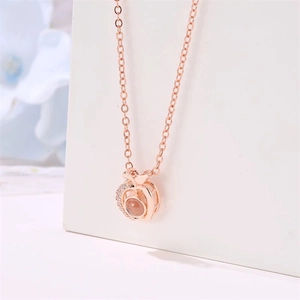 Detailed macro view of rose gold projection necklace with crystal-encrusted circular pendant