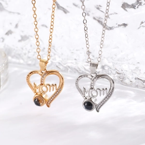 Detail of heart necklace with Mom lettering and projection stone in gold and silver