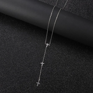 Macro shot of silver Y-shaped titanium steel necklace with three vertical cross pendants