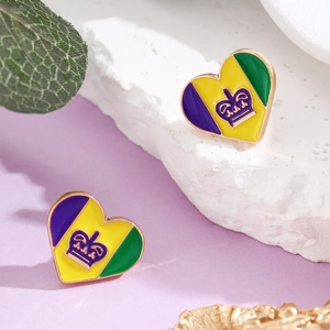 Macro shot of heart-shaped carnival enamel earrings with crown motif and gold trim