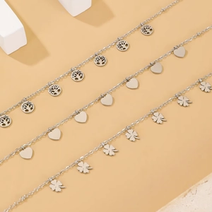 Titanium steel necklaces featuring tree of life, heart, and clover charms in silver finish