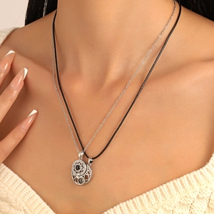 Detail of sun and moon magnetic necklaces with black gem and silver chain for couples
