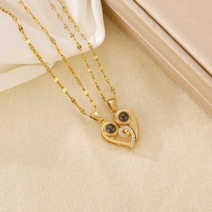 Detail of magnetic heart pendant necklace in gold finish with sparkling crystals