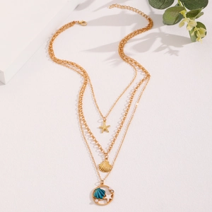 Detail of gold layered ocean necklace featuring starfish, shell and pearl pendants