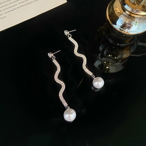 Detailansicht der S-förmigen Schlangenohrringe mit Zirkonia-Besatz und weißen Perlen