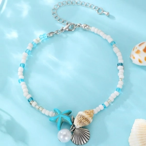 Detail of bohemian anklet with starfish charm, seashells, and blue beads for beach style