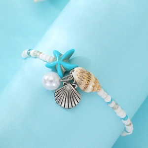 Detail of beach anklet with starfish charms, beads and sea shells for summer