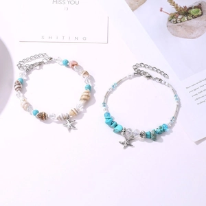 Close-up of bohemian starfish and seashell beaded anklets with turquoise stones