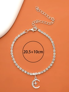 Détail de la chevillère en strass argentés avec un pendentif lune et étoile étincelant