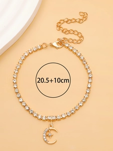 Détail de la chevillère dorée avec pendentif lune et étoile serti de cristaux brillants