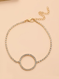 Détail d'une chaîne de cheville dorée avec cercle géométrique et fermoir mousqueton