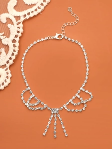 Détails du collier de strass argentés avec cristaux pendants et design d'ailes élégantes