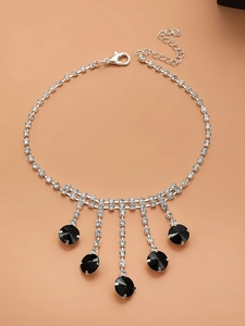 Détail du collier à pampilles argenté avec pierres noires et strass étincelants