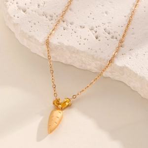 Detailaufnahme der goldenen Karotten-Halskette mit funkelnden eingelegten Zirkonia-Steinen