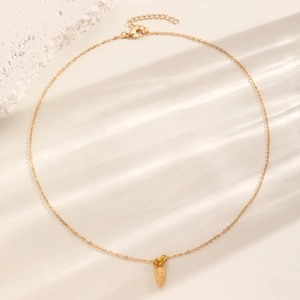Elegante goldfarbene Karotten-Halskette mit Zirkonia-Anhänger auf Stein-Hintergrund