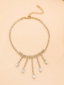 Détail de la chevillère dorée en strass avec chaînes à pampilles et gouttes de cristal brillant
