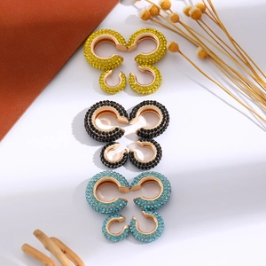 Dettaglio di orecchini a clip a farfalla dorati con strass multicolore brillanti