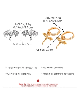 Detailed view of tiny silver dragon studs and gold hoop earrings with dimensions