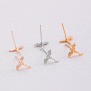 Detailed close-up of mini dragon stud earrings in gold, silver, and rose gold finishes