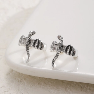 Macro detail of dragon ring showing intricate silver scales and wings in punk style