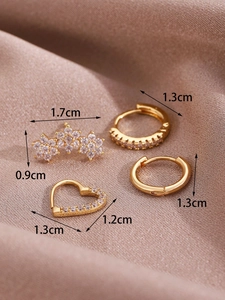 Detail shot of 14K gold hoop earrings set with cubic zirconia on champagne silk