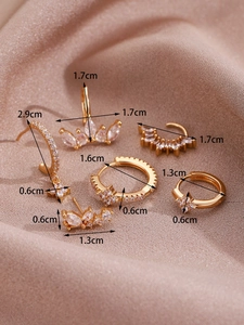 Detailed view of 14K gold-plated earrings set with zircon stones on silk background