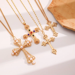 Detail of four gold cross necklaces with pearls and colorful zircon stones on stones