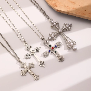 Detail of four cross pendants with pearls, colorful crystals, and vintage silver finish