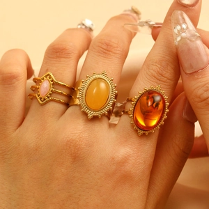 Detailaufnahme von Retro-Goldringen mit ovalen gelben und orangefarbenen Edelsteinen