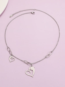 Detailed shot of steel dolphin heart pendant necklace with lobster clasp on lilac background