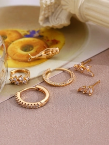 Detailed macro view of 14K gold plated hoop earrings and studs with micro-pave zirconia