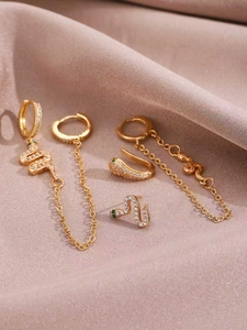 Detailed view of 14K gold snake earrings set with sparkling cubic zirconia and green eyes
