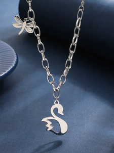 Macro view of stainless steel hip hop necklace with dragonfly and swan pendants