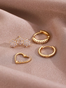 Detailed close-up of 14K gold-plated earring set with micro-pave heart and flower zircons