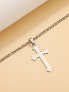Detailed view of silver gothic cross pendant in polished stainless steel on curb chain