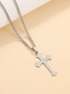 Macro detail of a silver stainless steel cross pendant with brushed metal texture