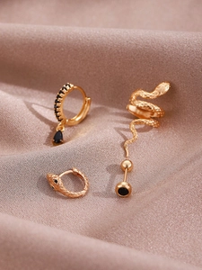 Detail of 14K gold-plated snake earrings set with black cubic zirconia on champagne silk