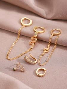 Detail of 5-piece 14K gold snake earrings set with white zircons and green crystal eyes
