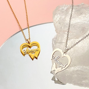 Macro shot of custom name necklace with heart and butterfly pendant in gold and silver